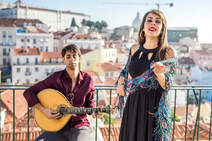 Local musicians perform traditional Fado music on a scenic rooftop in Lisbon, offering an authentic cultural experience for travelers.