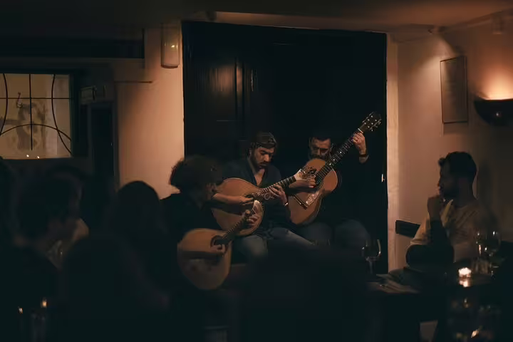 Intimate Lisbon fado performance with guitarists in a dimly lit venue, offering an authentic Portuguese cultural experience.