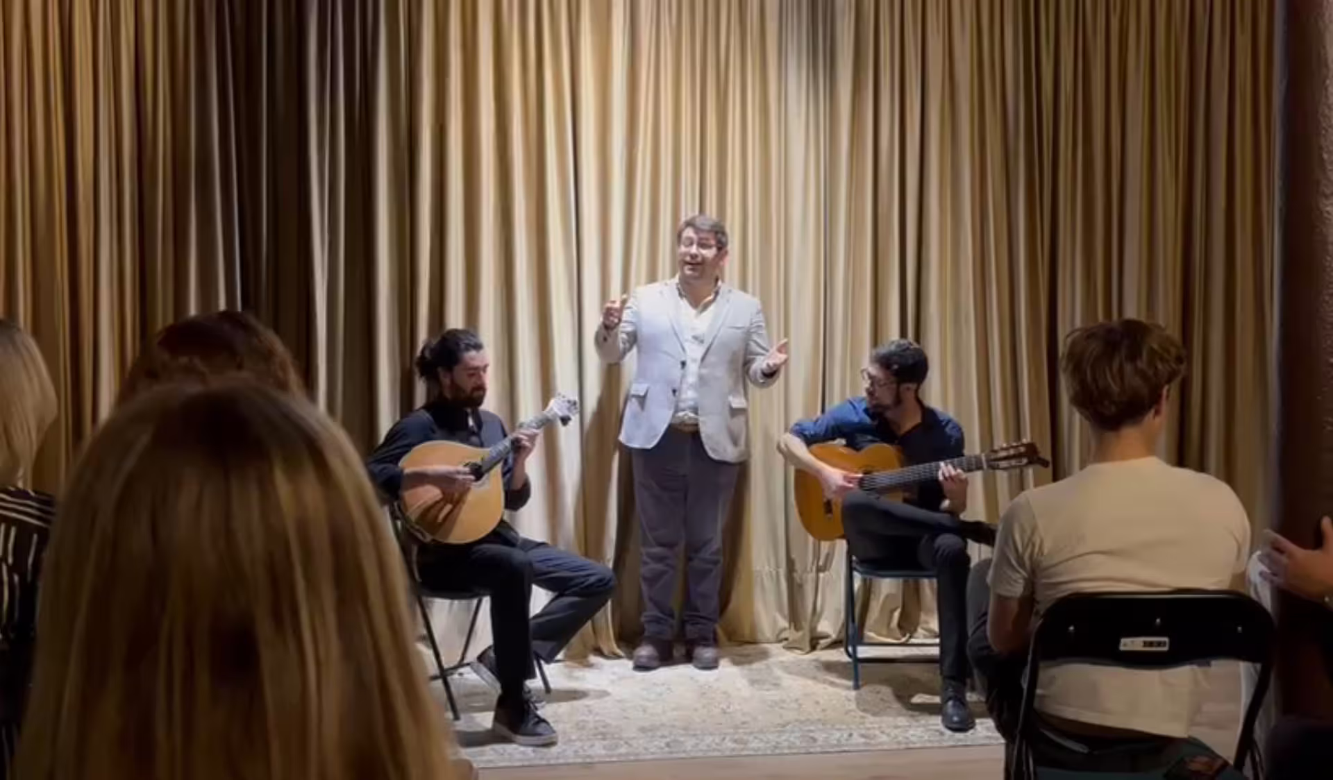Intimate live Fado session with singer and guitarists captivating an audience in a cozy setting.