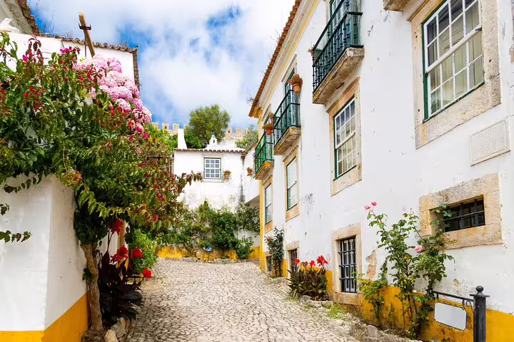 Charming cobblestone lane near Lisbon, scenic stop on customizable trip to Fatima, Batalha Monastery and Alcobaca