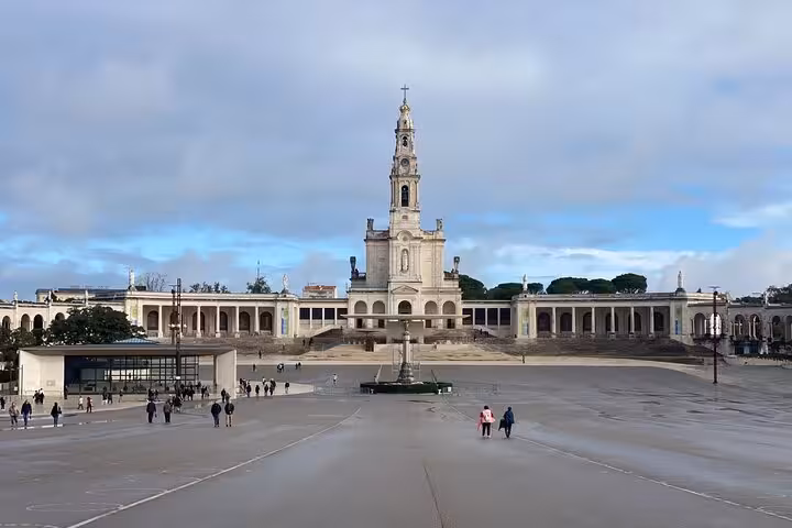 View of the Sanctuary of Fatima, a key destination on the Lisbon to Fatima guided tour, with people exploring the plaza.