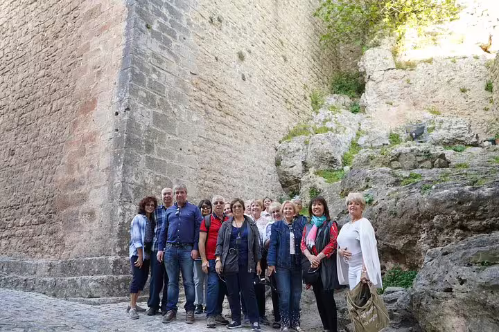 Group of tourists exploring historic stone architecture on a private full-day tour from Lisbon to Óbidos, Nazaré, Alcobaça, Batalha, and Fátima.