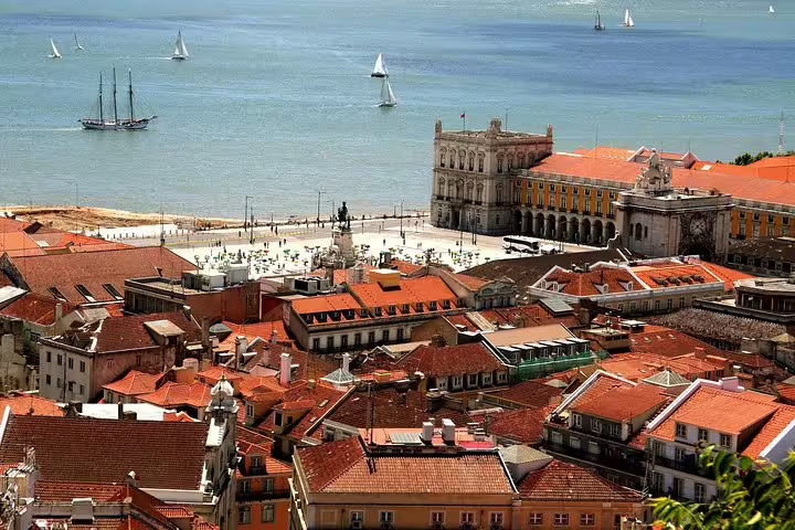 Scenic view of Lisbon's historic architecture and waterfront with sailboats, featured in a premium half-day private tour.