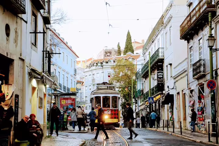 Historic Lisbon tram navigating a charming cobblestone street, capturing the essence of the Lisbon World Heritage Deluxe Tour.