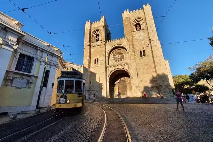 Historic tram passing Lisbon's iconic Sé Cathedral, capturing the essence of the Old Town during a private half-day tour.
