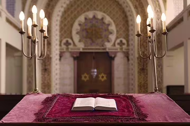 Historic synagogue interior with ornate decor and open prayer book, highlighting Lisbon's Jewish heritage on a private tour.