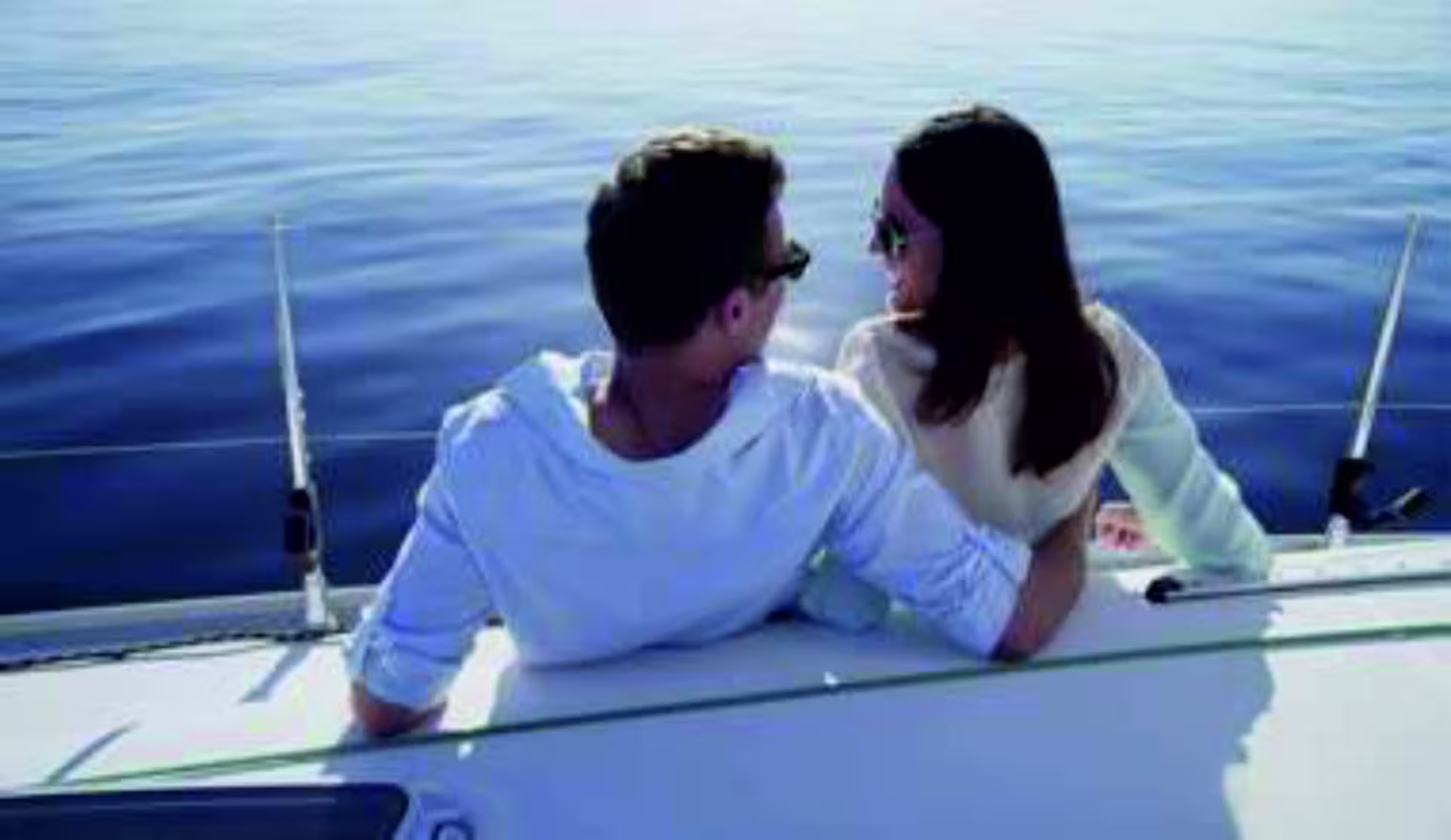 Romantic couple lounging on a luxury sailboat deck on the Tagus River, Lisbon private sunset cruise