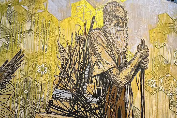 Detailed Lisbon mural of an elder with a staff, set against a striking, geometric yellow background.