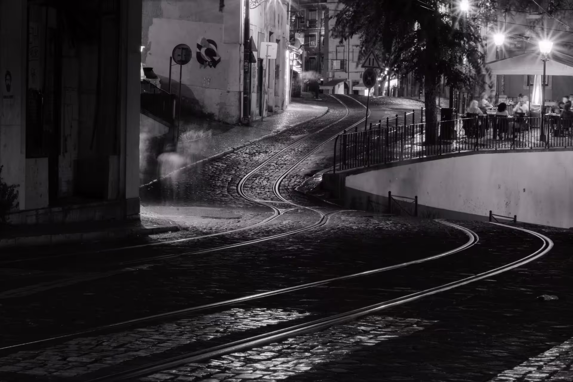 Enchanting cobblestone street and tram tracks in Lisbon at night, perfect for capturing stunning sunset photography on a private tour.