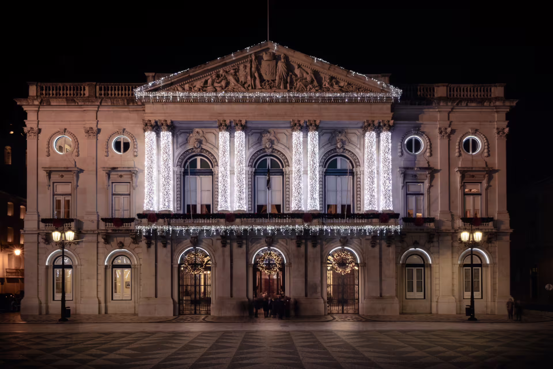 Illuminated historic building in Lisbon at night, showcasing festive Christmas lights during a private photo walk tour.