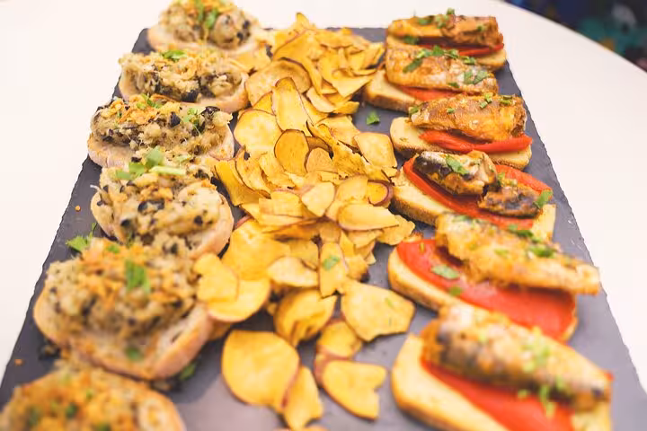 Portuguese tapas platter with sardine bruschetta and chips, Lisbon night tour food and drink tasting