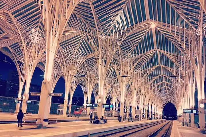 Modern architecture of Lisbon's Oriente Station illuminated at night, showcasing a stop on the premium private city tour.