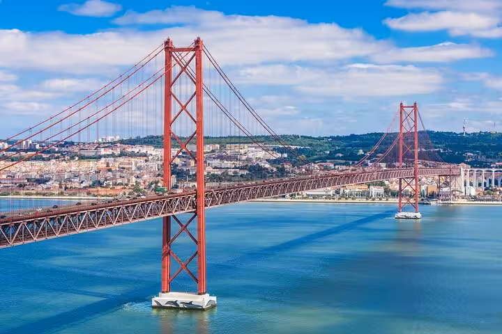 Scenic view of Lisbon's iconic suspension bridge over the Tagus River, featured in our Lisbon to Porto Mercedes transfer.