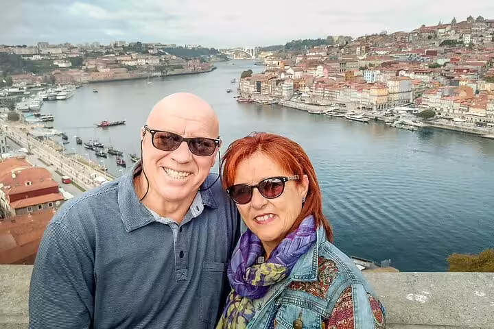 Couple enjoying scenic views of Porto's Douro River on a 2-day private tour from Lisbon, highlighting Portugal's vibrant landscapes.