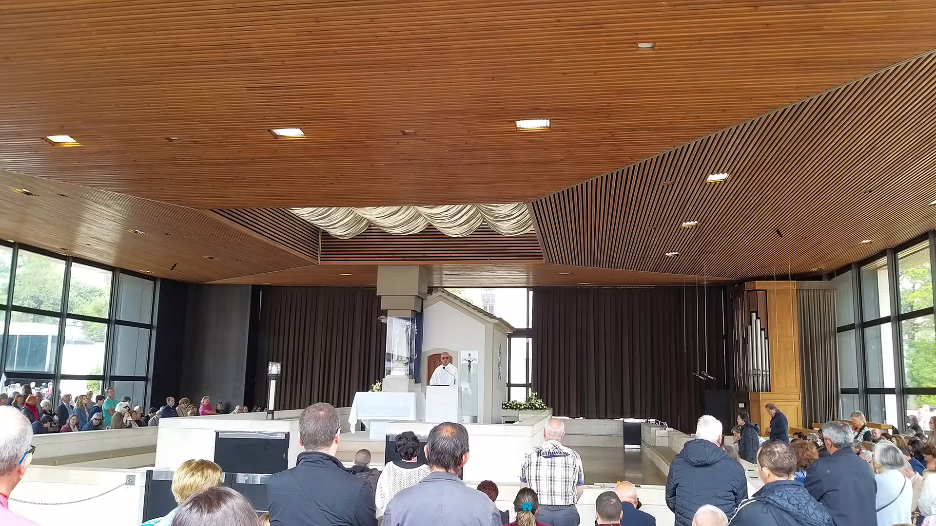 Interior view of a modern chapel in Portugal with visitors gathered, perfect for your private Lisbon to Porto tour adventure.