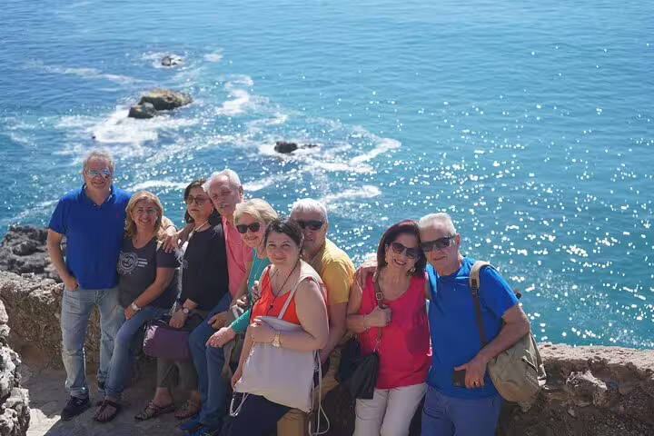 Group of tourists enjoying a scenic ocean view during a private 2-day tour from Lisbon to Porto, highlighting coastal beauty.