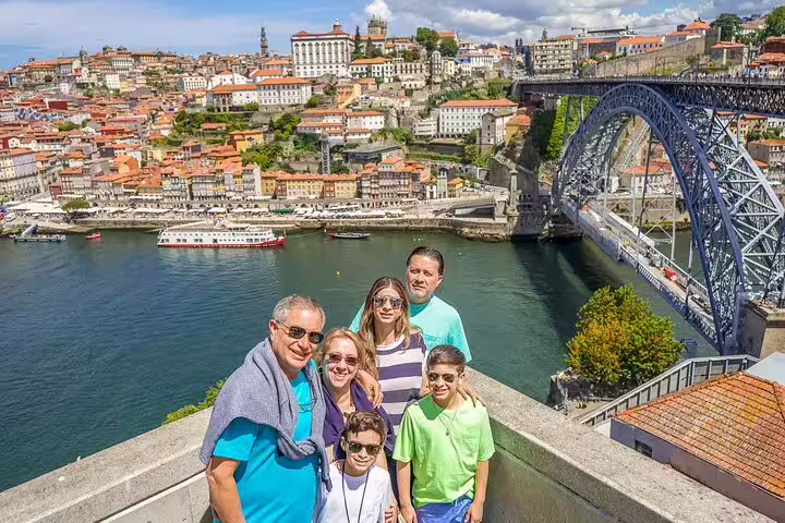 Family enjoying scenic view of Porto with Douro River and Dom Luís I Bridge during a private tour from Lisbon to Porto.