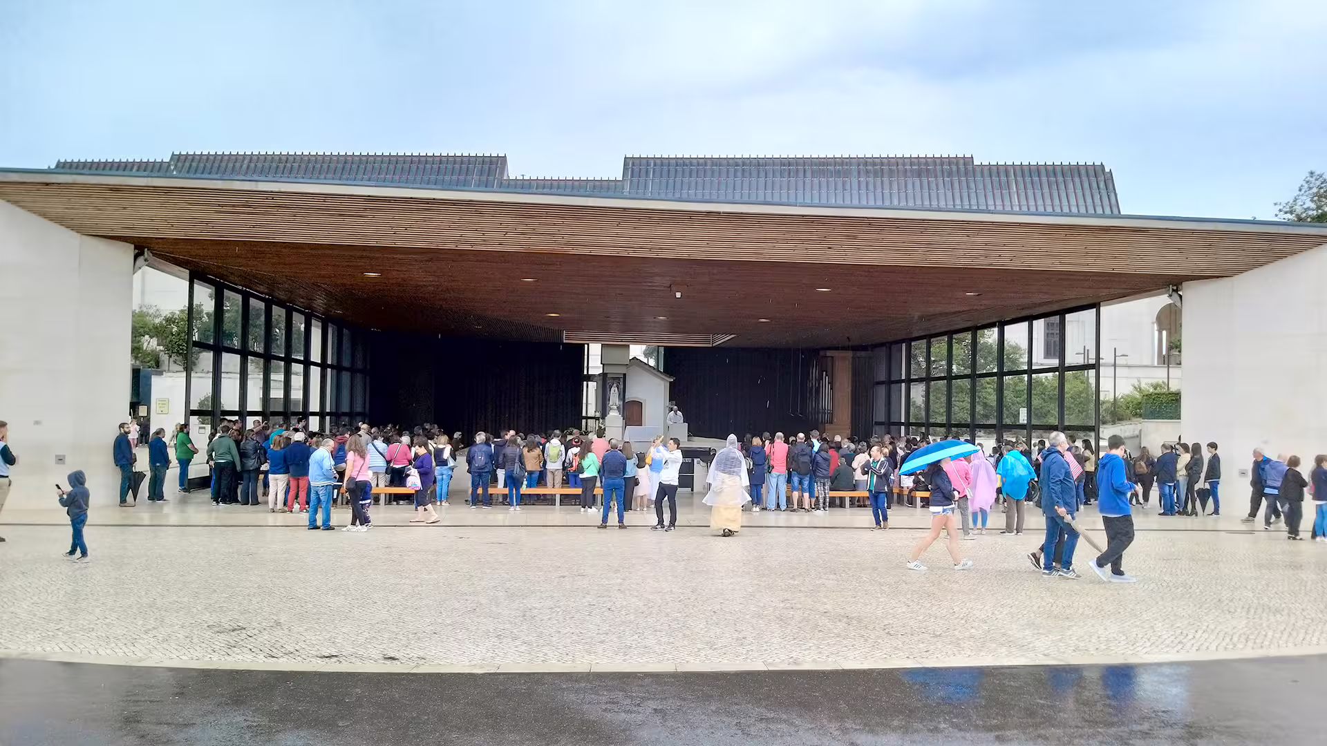Visitors gather at a modern, open-air pavilion in Fátima, a highlight on the customizable Lisbon to Porto private tour.