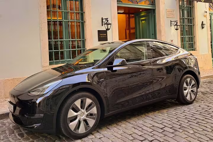 Sleek black car parked on cobblestone street, ideal for Lisbon to Porto private journey with customizable travel stops.