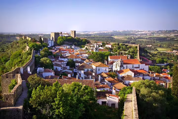Scenic view of Óbidos village and medieval castle on a Lisbon to Porto private journey with customizable stops in Portugal.