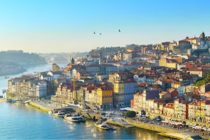 Scenic view of Porto's historic Ribeira district along the Douro River, highlighting colorful architecture on a Lisbon to Porto private journey.