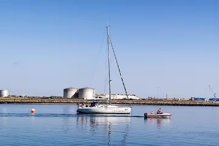Sailboats gracefully navigate the serene waters during a private Lisbon to Porto tour, offering a unique coastal adventure.