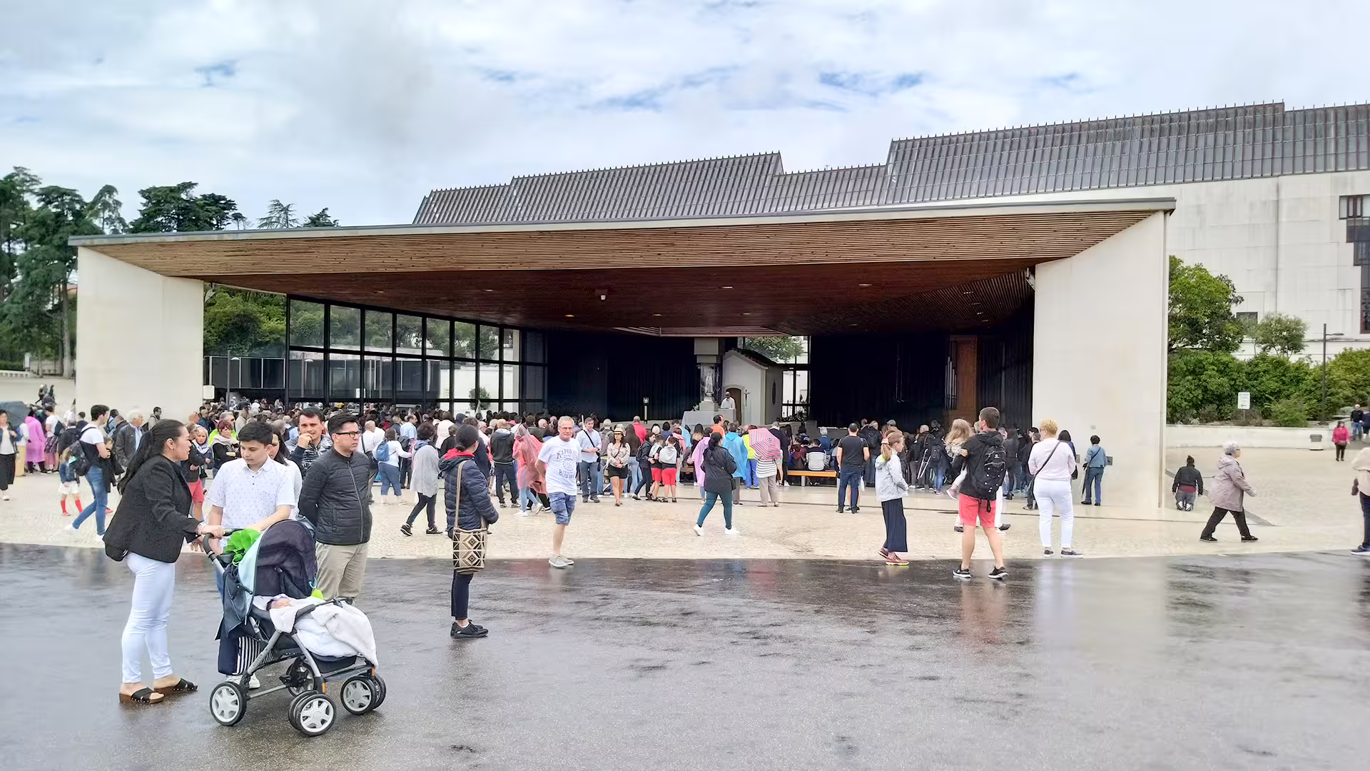 Crowds gather under modern architecture at a popular Lisbon landmark, highlighting vibrant stops on the Lisbon to Porto tour.