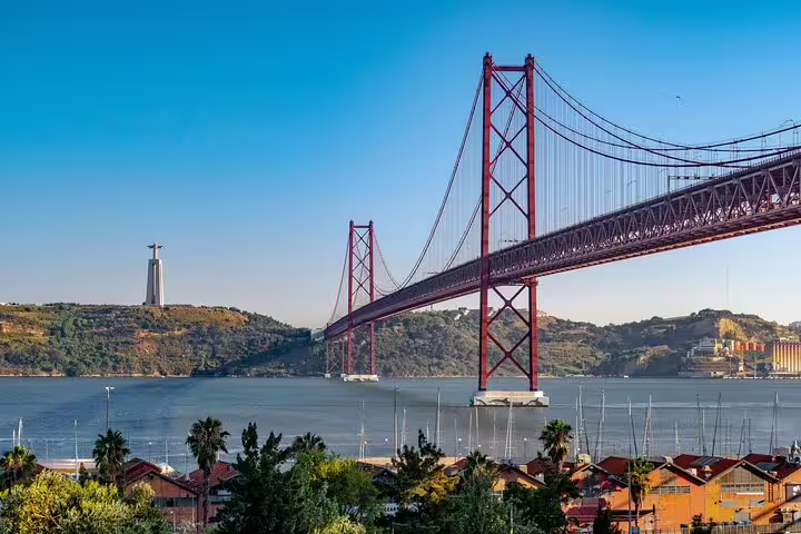 Stunning view of Lisbon's 25 de Abril Bridge over the Tagus River, ideal stop on Lisbon to Porto transfer journey.