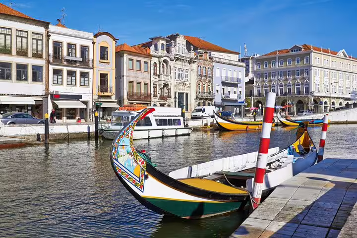 Scenic view of Aveiro canal with traditional moliceiro boats and colorful architecture, ideal for Lisbon to Porto private tour.
