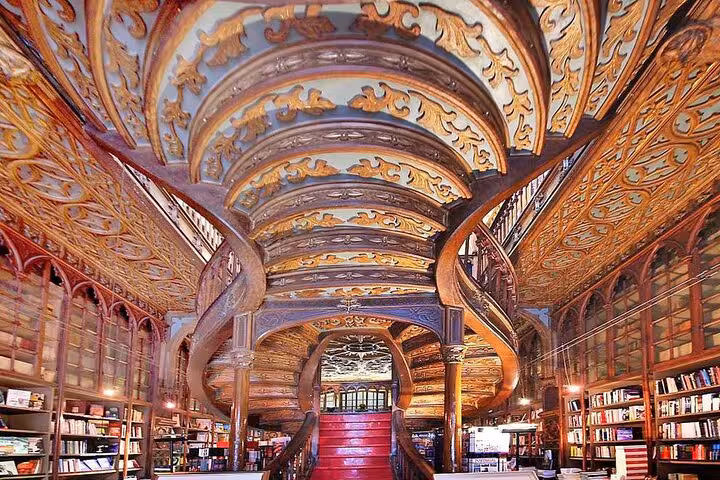 Majestic interior of Livraria Lello in Porto with ornate woodwork, featured in Lisbon to Porto private transfer tour.