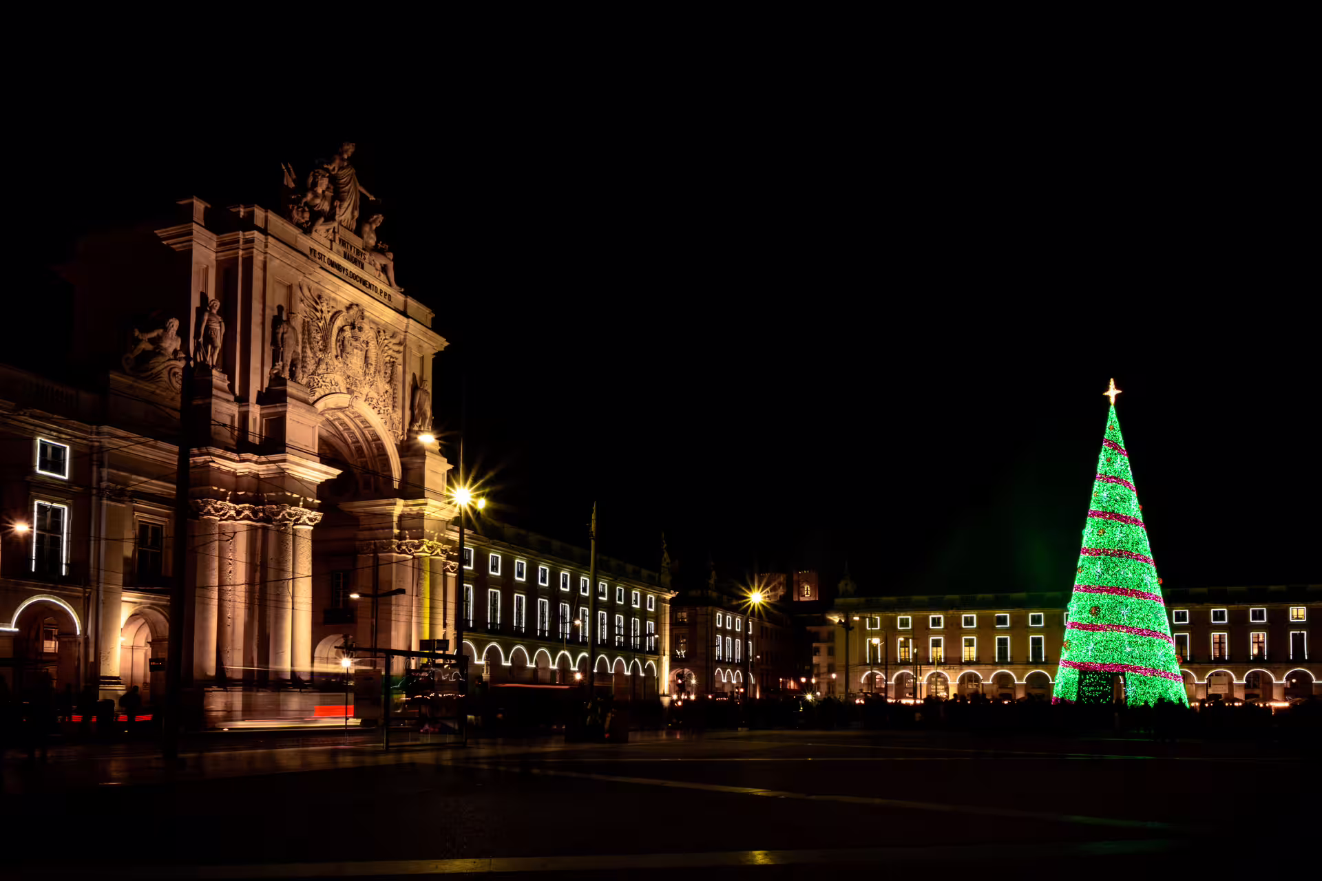Lisbon's Praça do Comércio glows with festive Christmas lights and a towering tree, perfect for a magical night photo walk.
