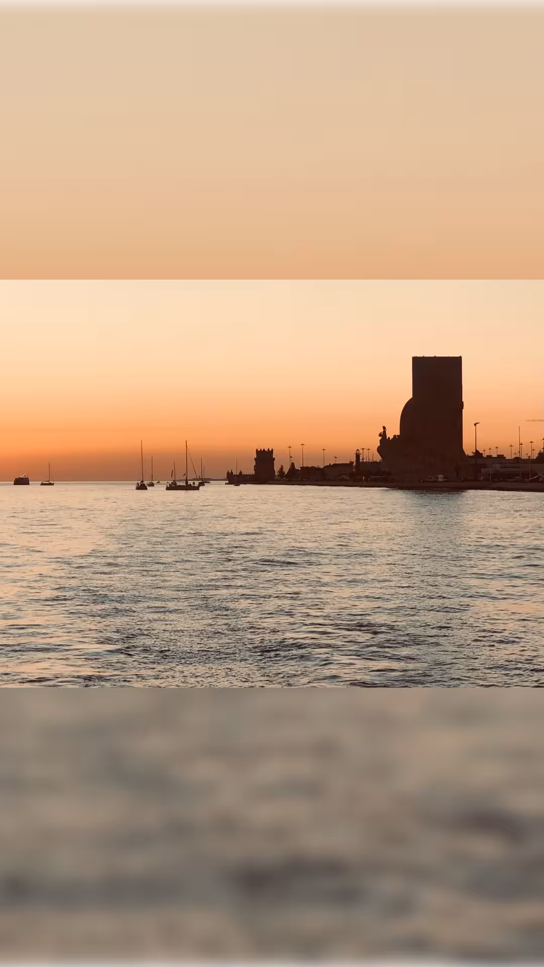 Lisbon private boat tour at golden hour with sailboats and Belém waterfront skyline on the Tagus River