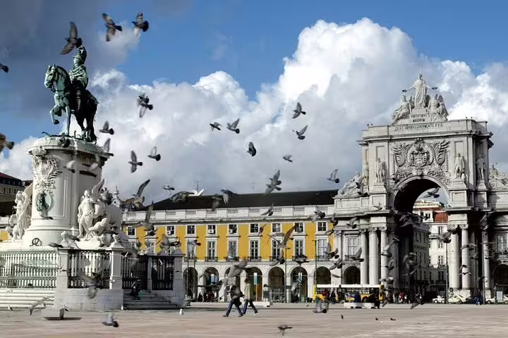 Lisbon private city tour showcasing Praça do Comércio with iconic statue, triumphal arch, and vibrant atmosphere.