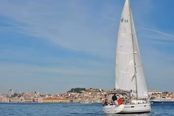 Lisbon private sailing cruise passing riverside palaces near Castelo de São Jorge on the Tagus River