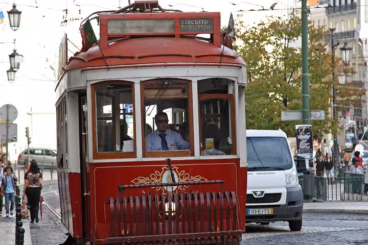 Historic red tram navigating the charming streets of Lisbon, perfect for exploring Portugal's capital city highlights.