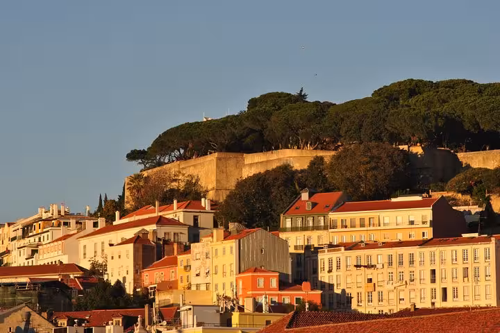 Lisbon waterfront skyline from Tagus River sailing tour, colorful Alfama buildings and São Jorge Castle