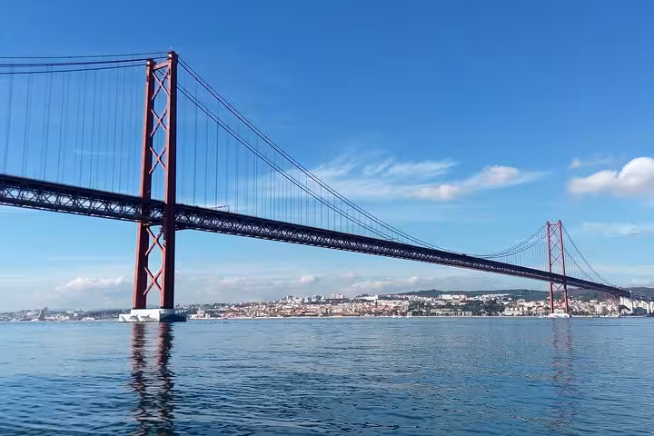 View of Lisbon 25 de Abril Bridge from the Tagus River on a luxury sailing tour, includes 2 drinks onboard