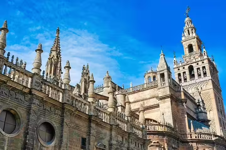 Majestic view of Seville Cathedral's intricate Gothic architecture under a clear blue sky, featured on the Lisbon to Seville private tour.