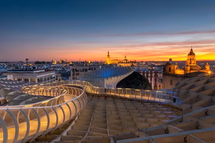 Panoramic sunset view from Seville's Metropol Parasol, showcasing the city's iconic skyline and vibrant evening colors.