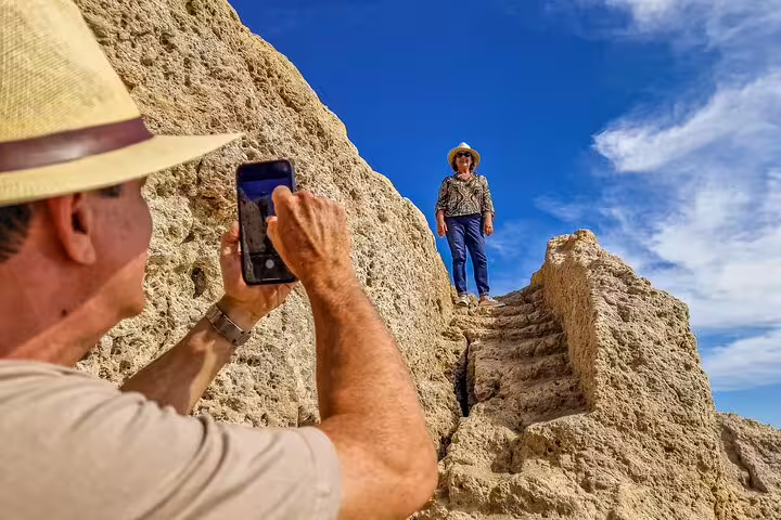 Travelers capture memories on ancient stone steps during a scenic Lisbon to Seville private transfer with Algarve stops.