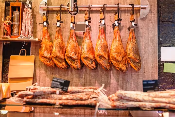 Traditional Spanish jamón hanging in Seville, a culinary highlight on the Lisbon to Seville private transfer tour.