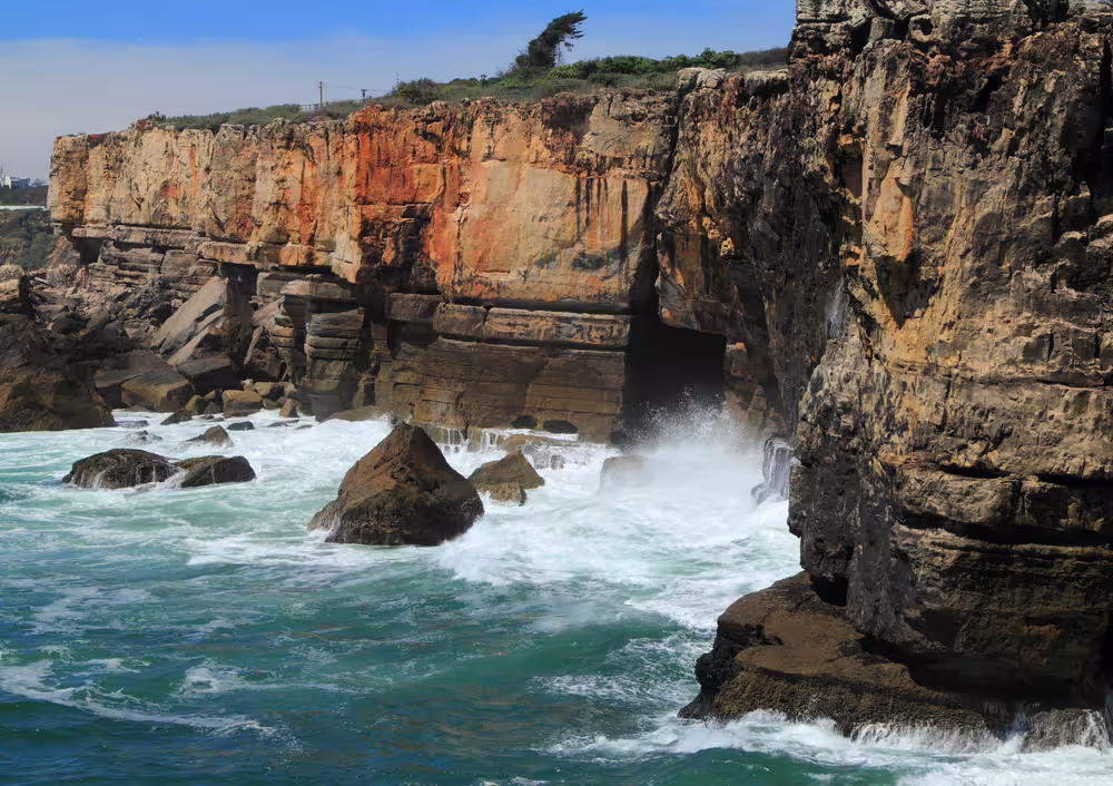 Dramatic coastal cliffs and crashing waves near Lisbon, part of the Sintra and Estoril shore excursion tour experience.