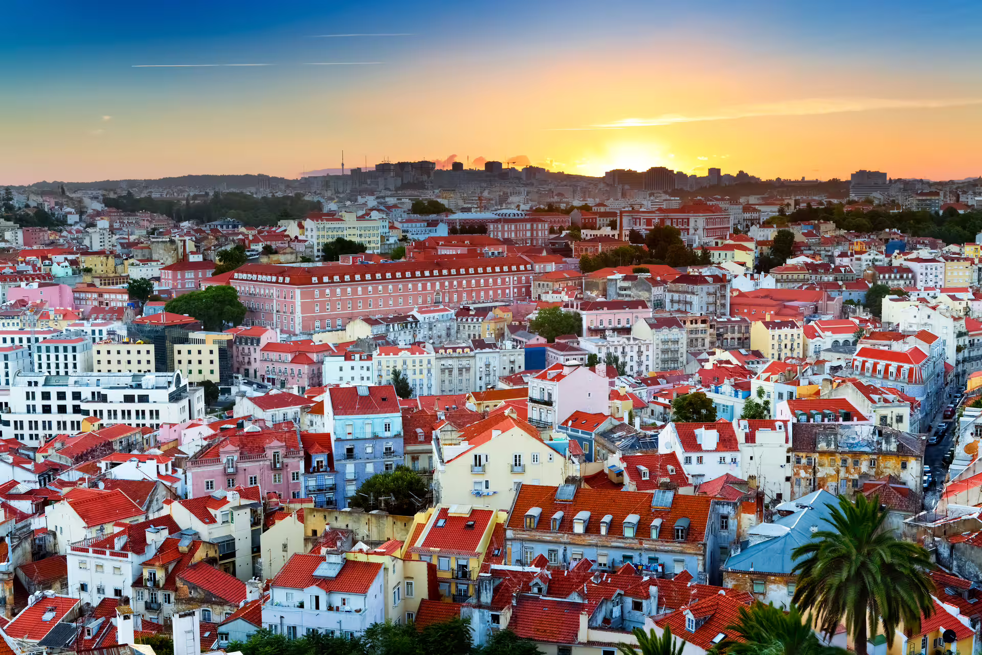 Colorful Lisbon cityscape at sunset, showcasing vibrant rooftops, perfect for a Sintra and Estoril shore excursion tour.
