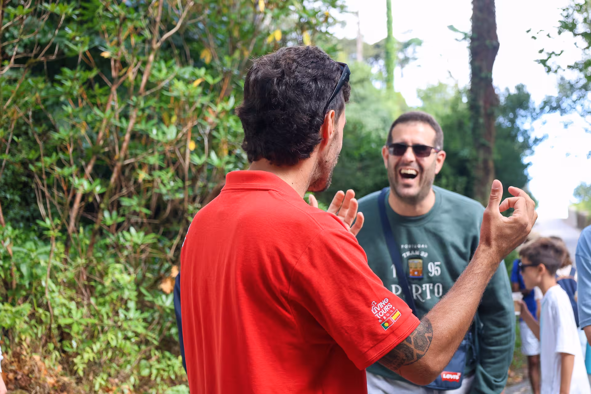 Tour guide engaging with tourists in a lush green setting during a Sintra day tour, showcasing Lisbon's friendly atmosphere.