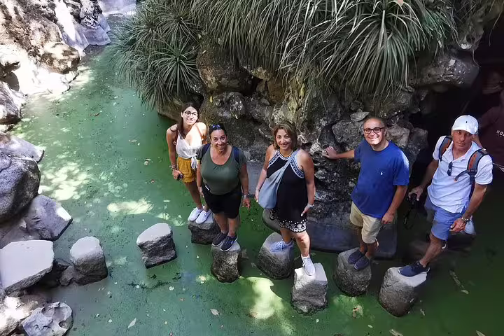 Group of tourists exploring lush greenery and stepping stones in Sintra during a private two-day tour near Lisbon and Cascais.