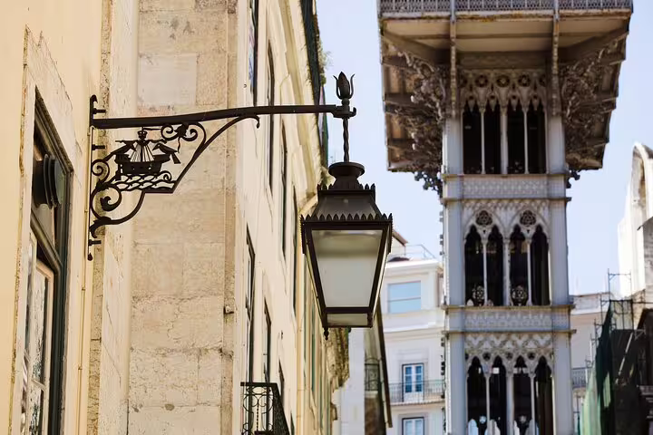 Ornate street lamp with Lisbon's iconic Elevador de Santa Justa in the background, perfect for newcomers exploring the city.