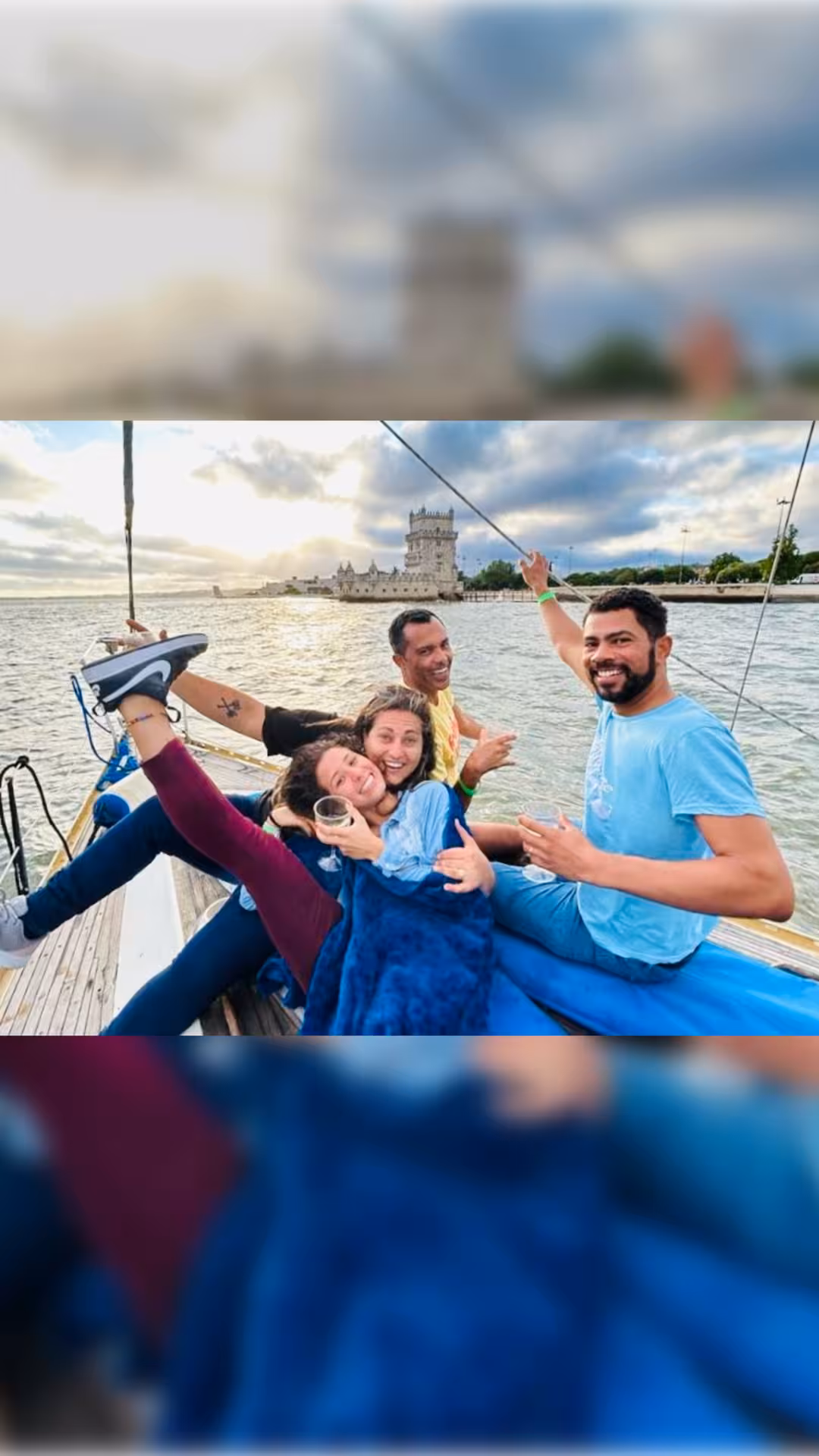 Friends relax on a Lisbon sunset boat tour with welcome drink, cruising by Belém Tower on the Tagus River