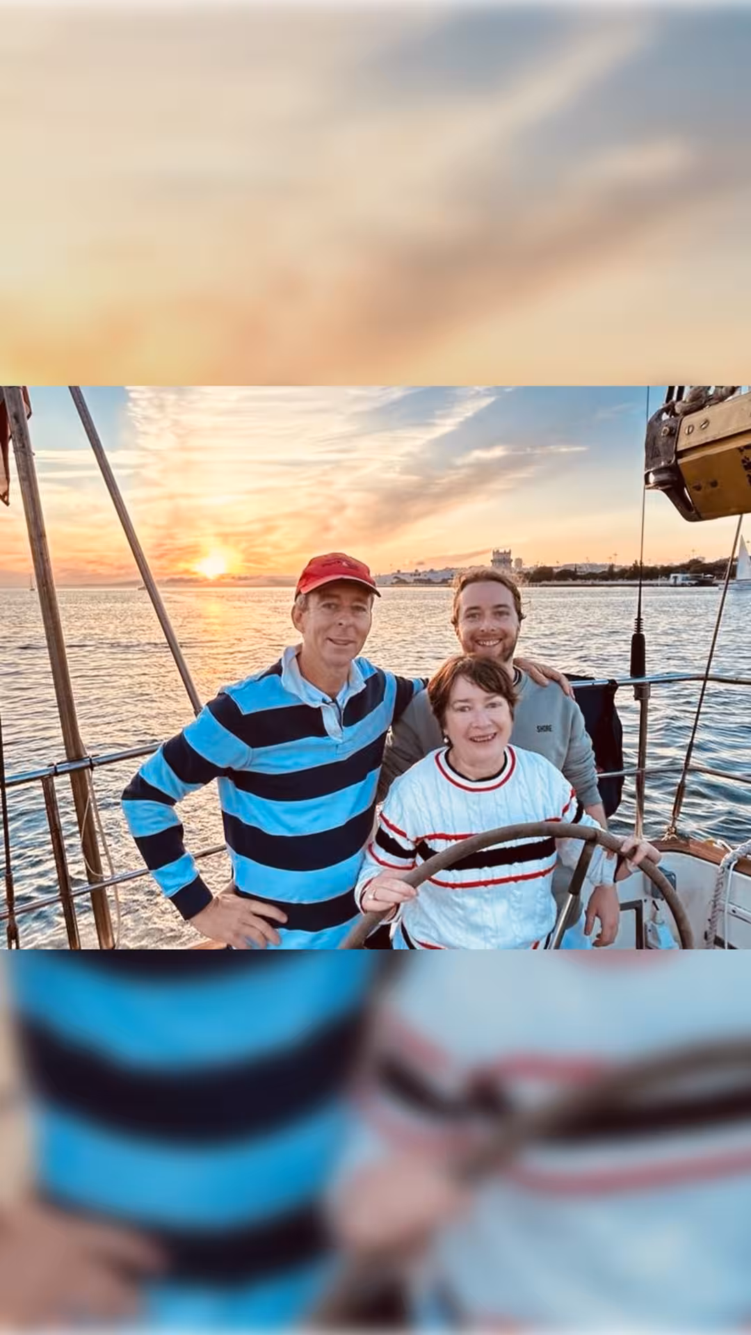 Guests pose at the helm on a Lisbon sunset sailboat tour with welcome drink, Tagus River glowing at sunset