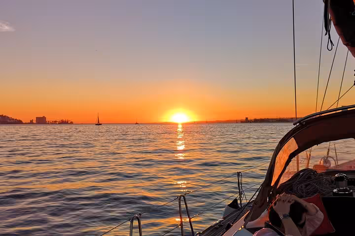 Golden Lisbon sunset over the Tagus River from a luxury sailing yacht, scenic sailing tour with 2 drinks included