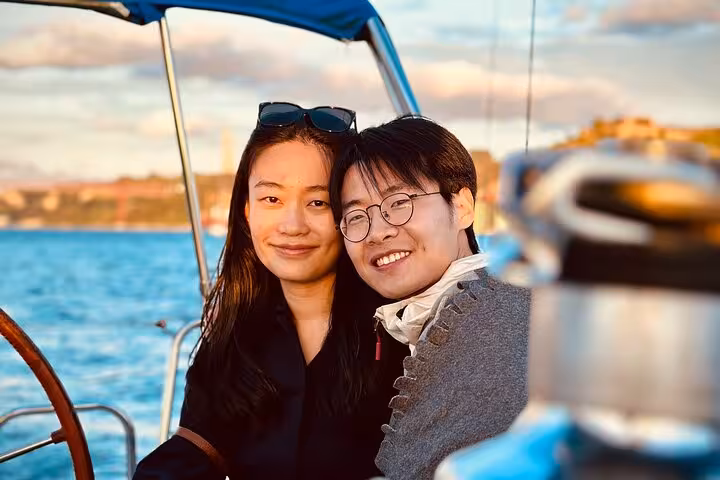 Couple enjoying Lisbon sunset sailing on the Tagus River, relaxing 2-hour cruise after tuk-tuk tour